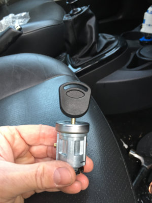 Hand holding a cylindrical key locking mechanism.